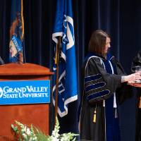 Bob Smart at podium, Provost handing recipient an award